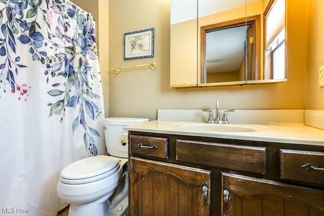 full bath with toilet, curtained shower, and vanity