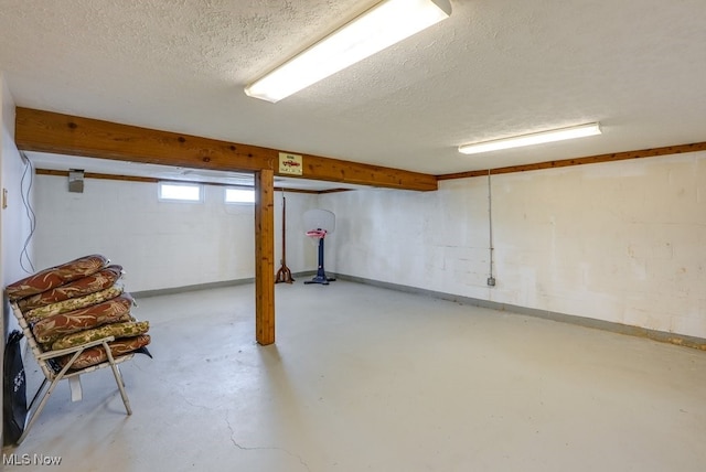 basement featuring a textured ceiling and concrete block wall