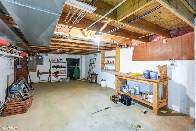 unfinished basement with electric panel and a workshop area