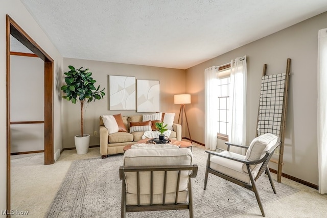 living area featuring light carpet, a textured ceiling, and baseboards