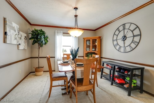 carpeted dining room featuring baseboards, a textured ceiling, and ornamental molding