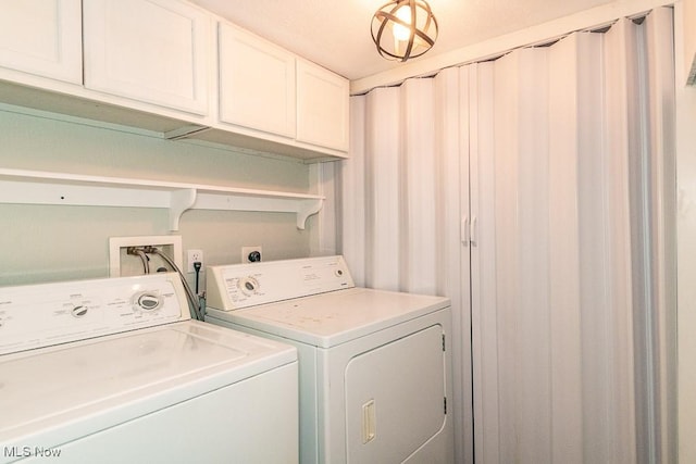 washroom with washer and clothes dryer and cabinet space