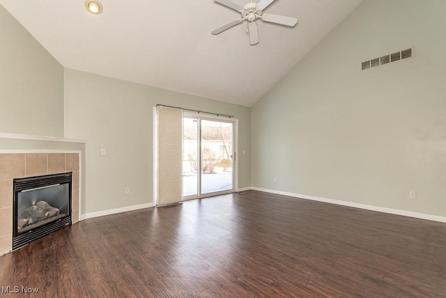 unfurnished living room with dark wood-style flooring, visible vents, baseboards, and a tiled fireplace