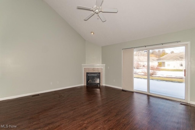 unfurnished living room with dark wood-style flooring, ceiling fan, a tiled fireplace, lofted ceiling, and visible vents
