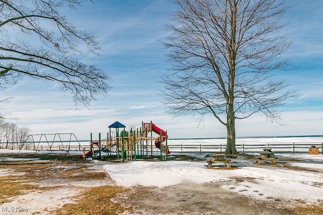 snow covered playground featuring playground community and fence