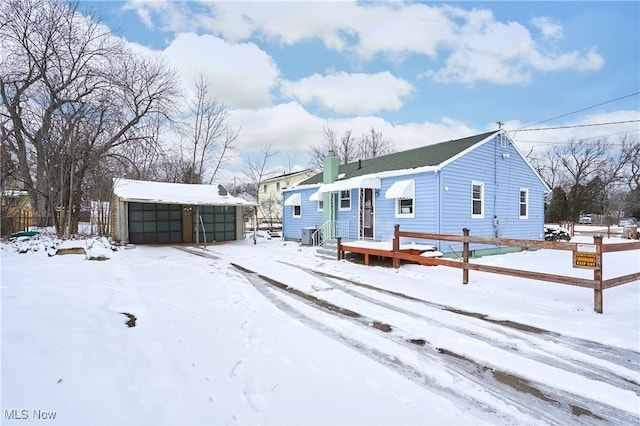 view of front of property with an outbuilding, a detached garage, and a chimney