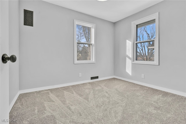 carpeted empty room with baseboards, visible vents, and a healthy amount of sunlight