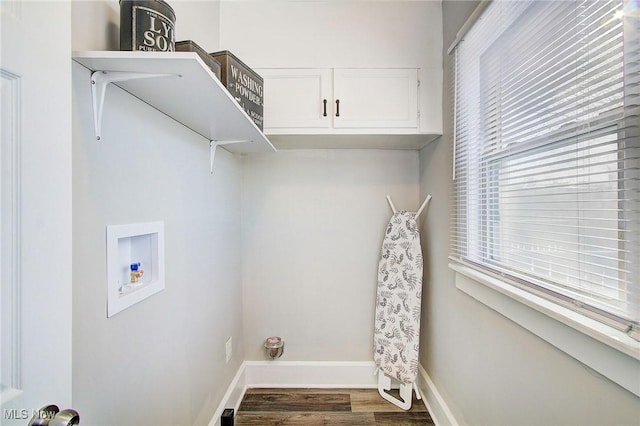 laundry room featuring dark wood-type flooring, hookup for a washing machine, cabinet space, and baseboards