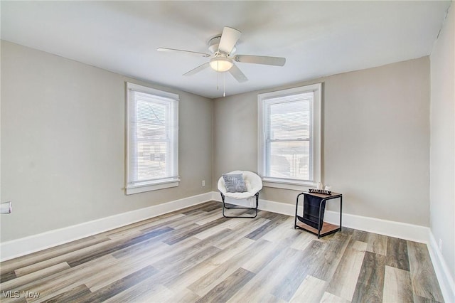 unfurnished room featuring baseboards, light wood finished floors, and a healthy amount of sunlight