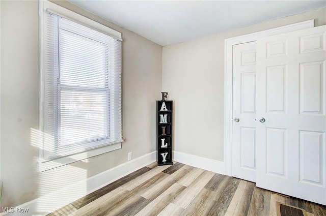 interior space featuring visible vents, light wood-style flooring, and baseboards