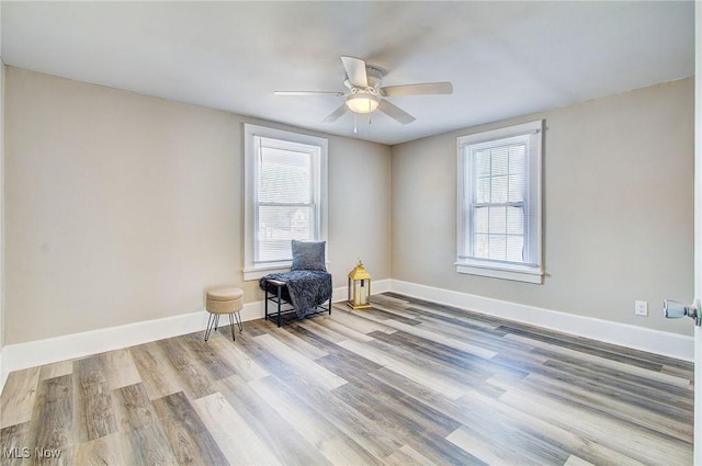 unfurnished room with ceiling fan, light wood-style flooring, and baseboards