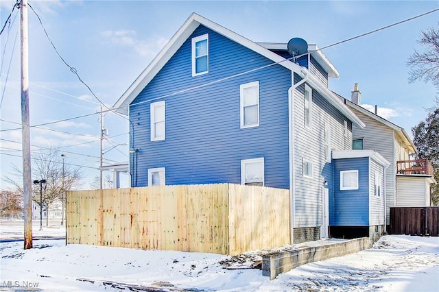 view of snow covered exterior featuring fence