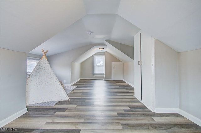 bonus room featuring vaulted ceiling, baseboards, and wood finished floors