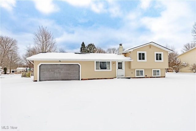 split level home featuring a garage and a chimney