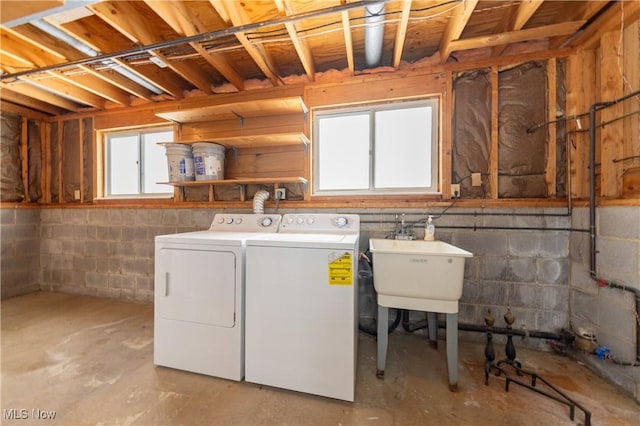 clothes washing area featuring a sink and separate washer and dryer