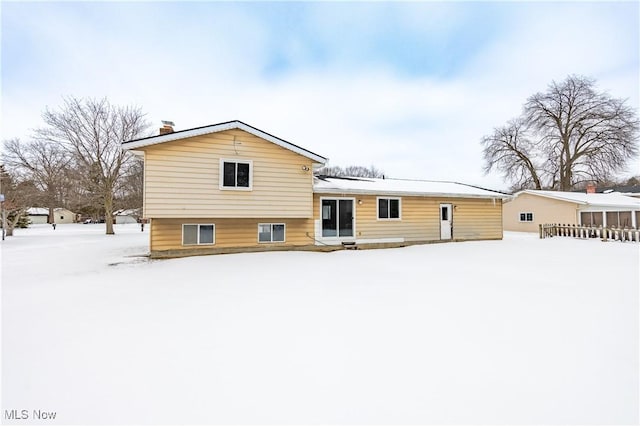 snow covered property with a chimney