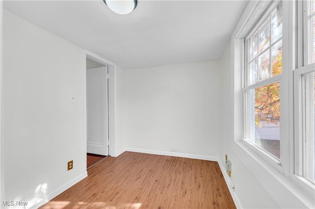 spare room featuring light wood finished floors and baseboards