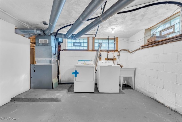 interior space with heating unit, visible vents, and washer and clothes dryer