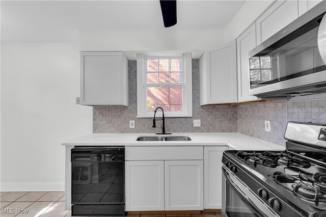 kitchen featuring white cabinetry, stainless steel appliances, a sink, and light countertops