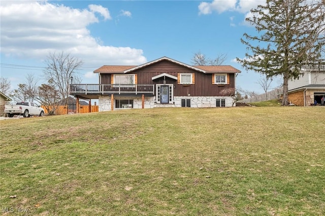 back of house with a deck and a lawn