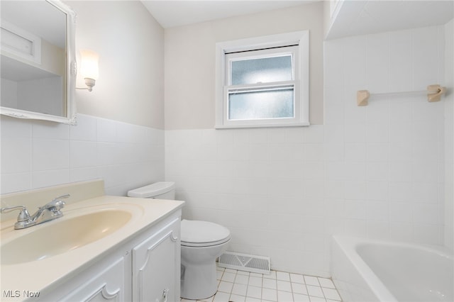 bathroom featuring visible vents, tile walls, tile patterned floors, vanity, and a bath