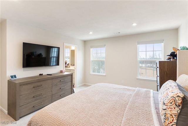 bedroom with baseboards, recessed lighting, ensuite bathroom, and light colored carpet