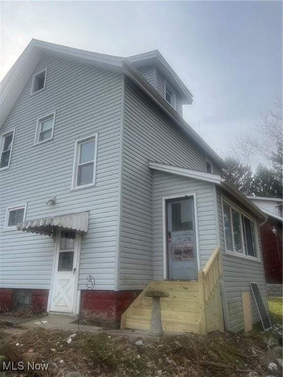 rear view of house featuring entry steps