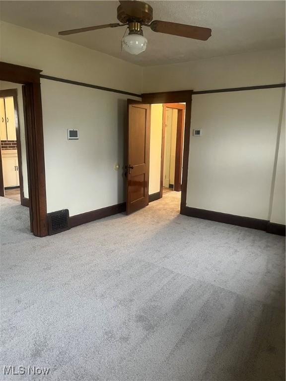 unfurnished bedroom with ceiling fan, baseboards, and light colored carpet