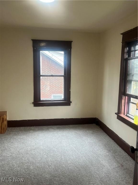 unfurnished room with baseboards and carpet flooring