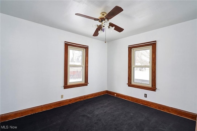 empty room with carpet flooring, a ceiling fan, and baseboards