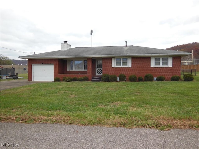 ranch-style home with driveway, brick siding, an attached garage, and a front yard