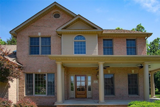 view of front facade with covered porch, brick siding, and a ceiling fan