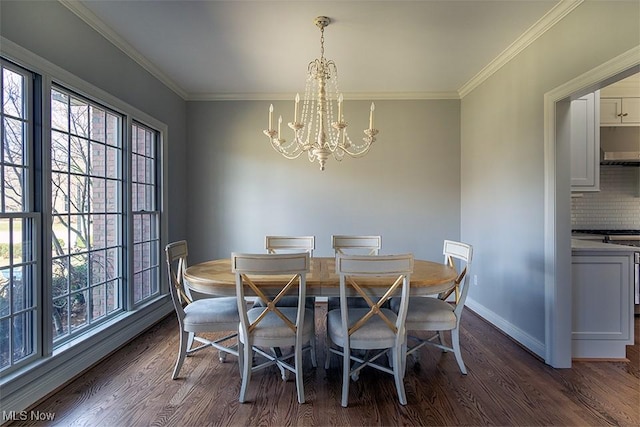 dining space featuring dark wood-style floors, baseboards, ornamental molding, and a notable chandelier