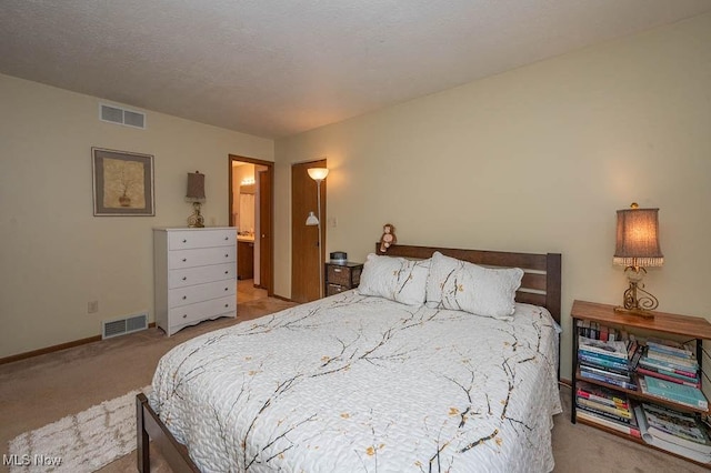 bedroom with light carpet, a textured ceiling, visible vents, and baseboards