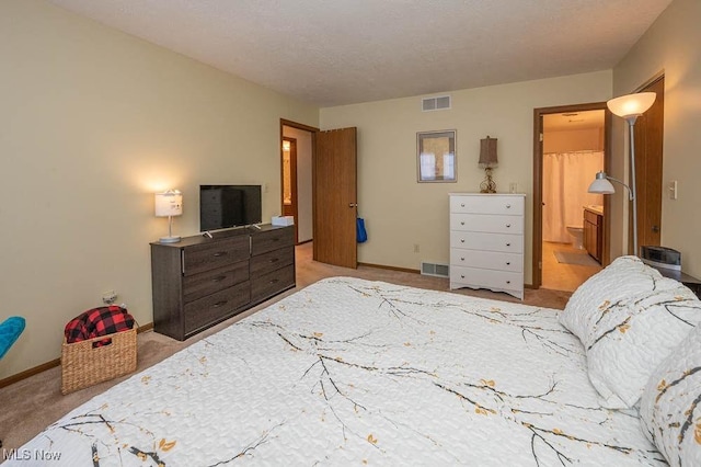 bedroom featuring visible vents, light carpet, baseboards, and ensuite bathroom