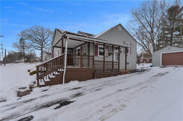 view of front of house featuring covered porch, a detached garage, and an outdoor structure