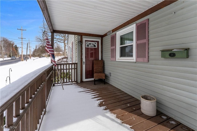 view of snow covered back of property