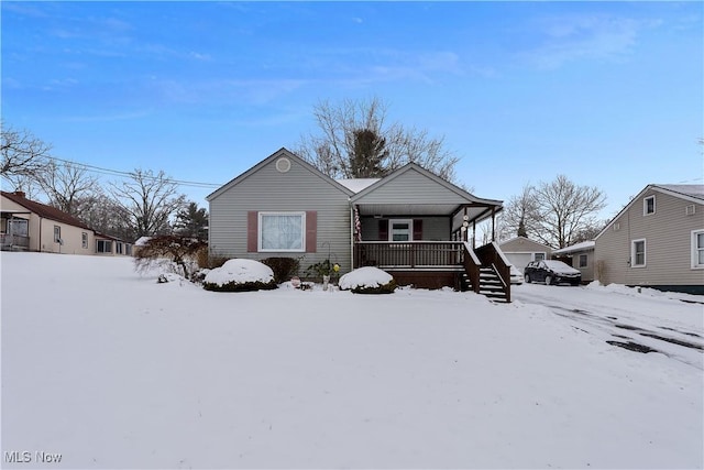 view of front of home featuring covered porch and a detached garage