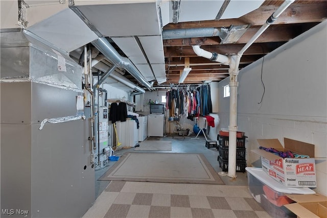 below grade area featuring water heater and washer and clothes dryer