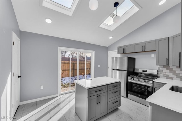 kitchen with a kitchen island, marble finish floor, stainless steel appliances, light countertops, and pendant lighting