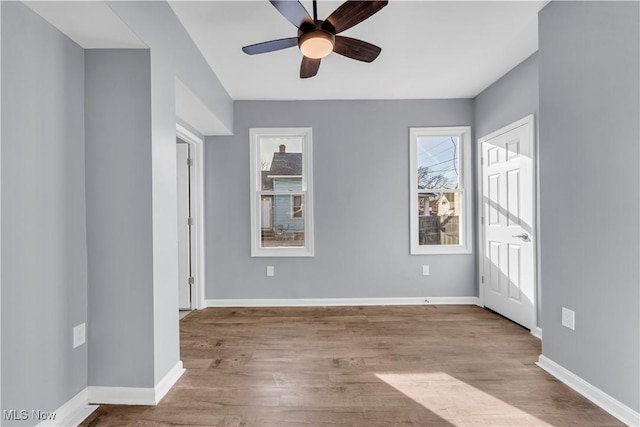 unfurnished room featuring light wood-style flooring, baseboards, and ceiling fan