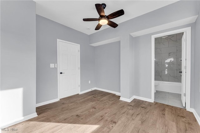 empty room with light wood-type flooring, ceiling fan, and baseboards