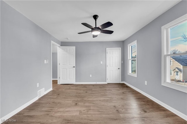 unfurnished bedroom with baseboards, visible vents, ceiling fan, and light wood finished floors