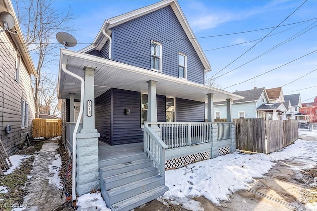 view of front of home featuring covered porch and fence