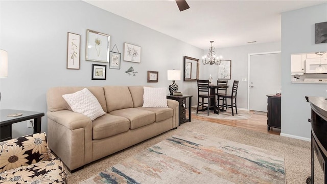 living area featuring baseboards and a notable chandelier