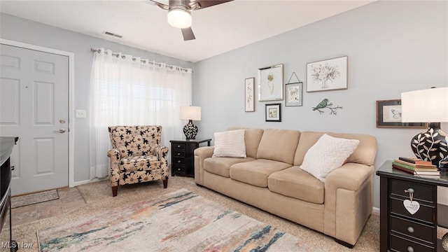 living area featuring baseboards, visible vents, and a ceiling fan