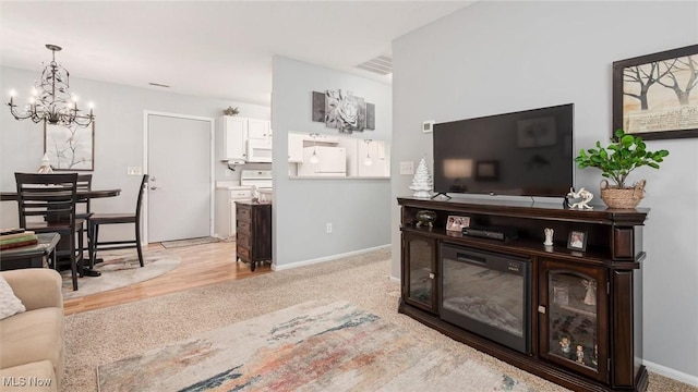 living area with visible vents, baseboards, and a notable chandelier