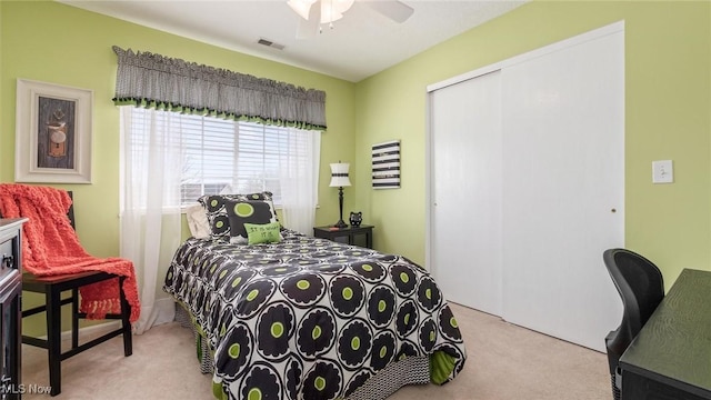 bedroom with a ceiling fan, light colored carpet, a closet, and visible vents