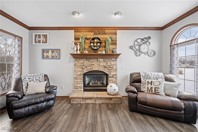 living area featuring a fireplace, crown molding, baseboards, and wood finished floors