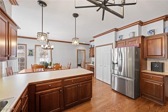 kitchen featuring light countertops, light wood finished floors, decorative light fixtures, and stainless steel fridge with ice dispenser